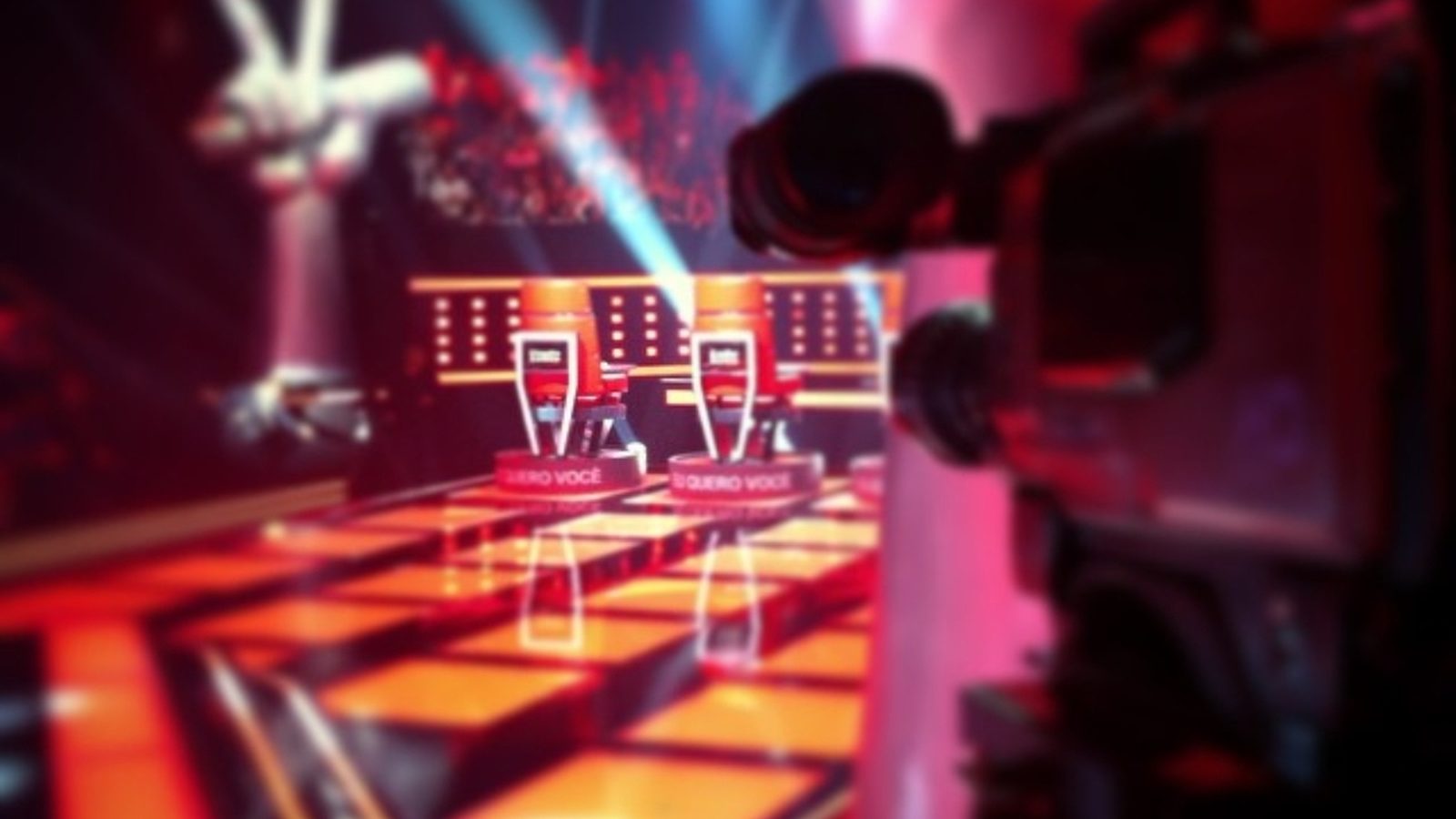 Cámara de estudio apuntando a las sillas de los coaches en el escenario de The Voice Brasil